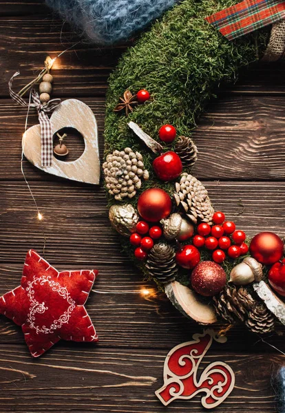 Ahşap arka plan üzerinde parlak parlak süslemeleri ile Noel çelenk