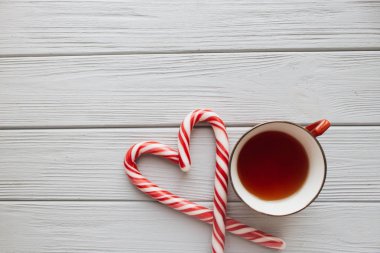 Kalp şeklinde ve çay ahşap arka plan üzerinde Noel candy köpekler