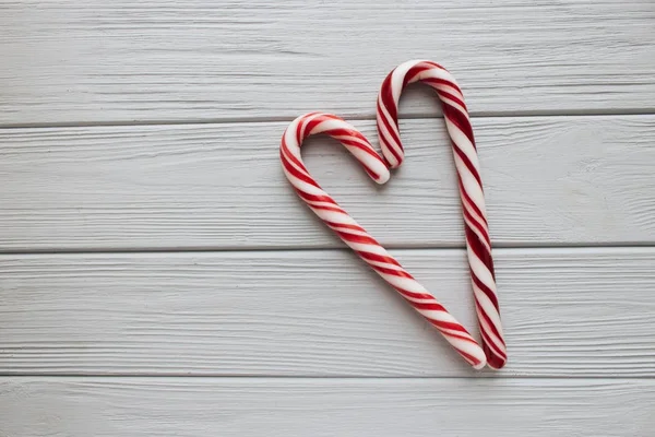 Ahşap arka plan üzerinde kalp şeklinde Noel candy köpekler