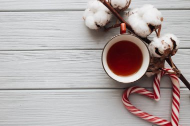 Kalp şeklinde, pamuk şube ve çay ahşap arka plan üzerinde Noel candy köpekler