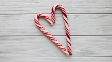 Ahşap arka plan üzerinde kalp şeklinde Noel candy köpekler