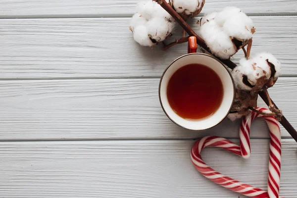 Kalp şeklinde, pamuk şube ve çay ahşap arka plan üzerinde Noel candy köpekler