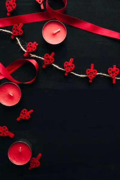 clips with hearts,  candles, ribbon  on black  background with copy space