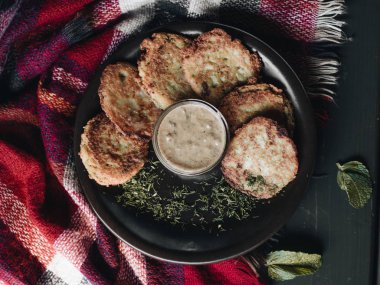 ekşi krema sosu ve siyah plaka üzerinde otlar ile lezzetli kızarmış patates kek