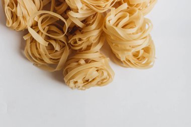 Beyaz arka plan üzerinde pişmemiş makarna yığını    