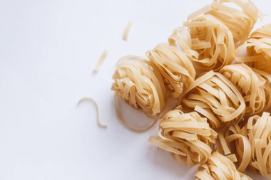 Beyaz arka plan üzerinde pişmemiş makarna yığını    