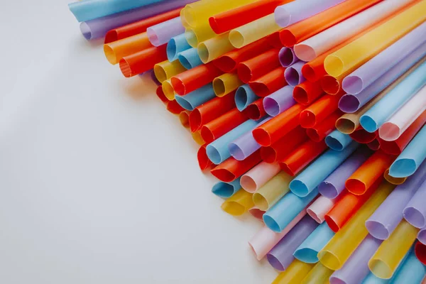 pile of colorful cocktail straws over white background