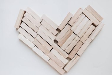 Jenga masa oyunu, beyaz arka planı için küçük ahşap blokların yapılan kalp