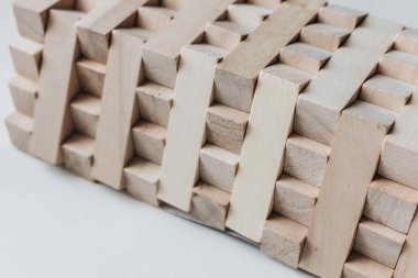 Jenga masa oyunu, beyaz arka planı için küçük ahşap blok inşaatı
