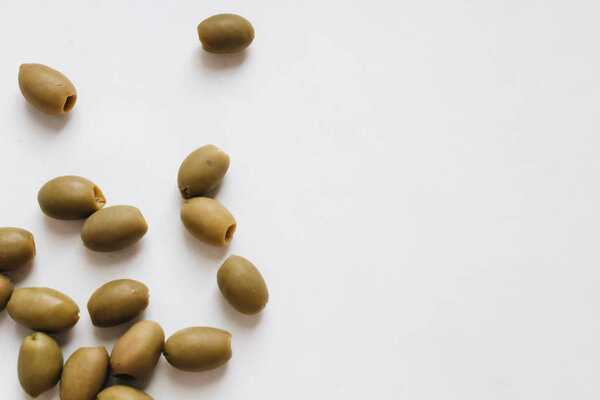 pile of delicious green olives on white background