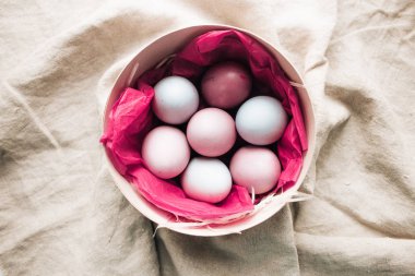  kutusunda pembe kağıt, çul arka plan, rustik şenlikli kompozisyon ile boyalı Paskalya yumurtaları
