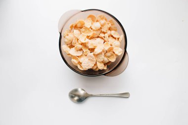 Beyaz arka plan, kaşık kase lezzetli çıtır Mısır gevreği sağlıklı kahvaltı