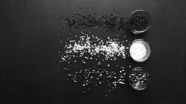 gözlük aromalı tuz, çeşitli peppercorns ve baharat siyah arka plan, siyah ve beyaz ile