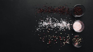 gözlük aromalı tuz, çeşitli peppercorns ve siyah arka plan üzerinde kırmızı baharat