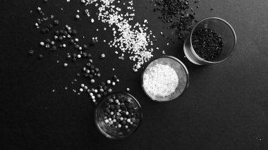 gözlük aromalı tuz, çeşitli peppercorns ve baharat siyah arka plan, siyah ve beyaz ile