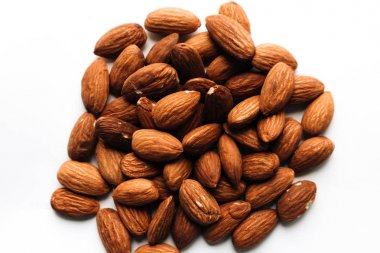 Beyaz arka plan, sağlıklı beslenme kavramı üzerine badem yığını