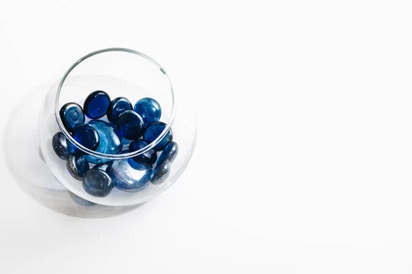 白色背景玻璃花瓶中的蓝色小石头堆 — 图库照片
