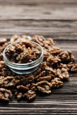 Kabuklu ceviz ahşap zemin, sağlıklı beslenme kavramı üzerine cam küçük kapta yığını