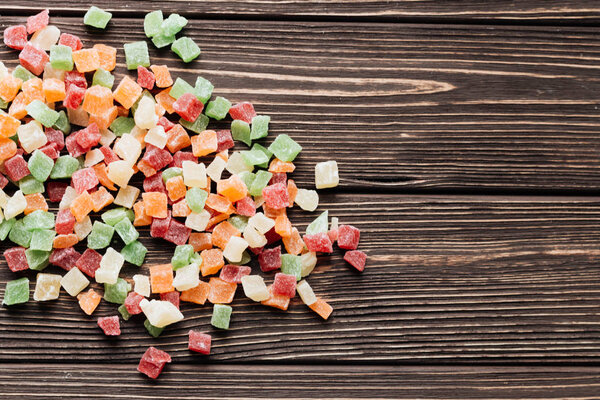 pile of sweet colorful candied fruits on wooden table