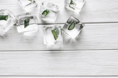 buz küpleri ile beyaz ahşap tablo içinde donmuş aloe düz lay 