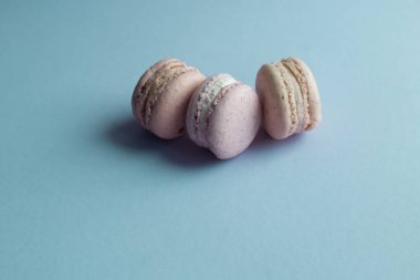 kompozisyon üç lezzetli renkli macaroons mavi masada, tatlı tatlı 