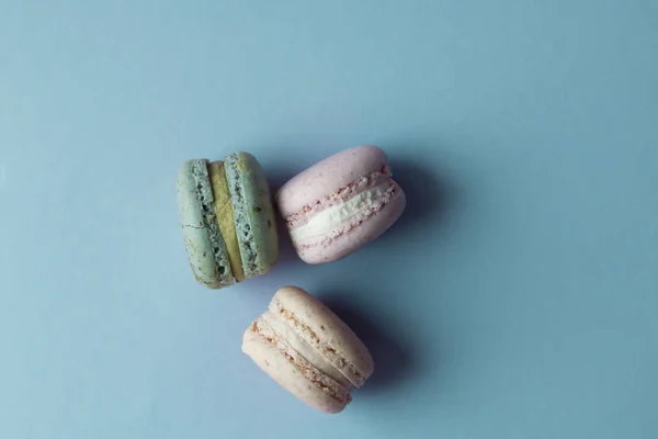 Три Вкусных Красочных Макарон Голубом Столе Сладкий Десерт — стоковое фото