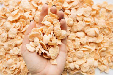 lezzetli çıtır Mısır gevreği, gıda arka plan, sağlıklı kahvaltı yığını tutan el