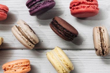 Beyaz ahşap masa, tatlı tatlı üzerinde lezzetli renkli macaroons 