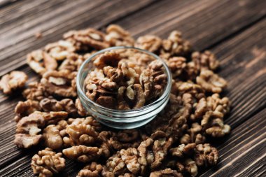 Kabuklu ceviz ahşap zemin, sağlıklı beslenme kavramı üzerine cam küçük kapta yığını