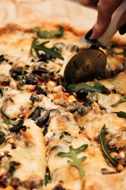 peynir, ruccola ve zeytin lezzetli pizza Dilimleme el