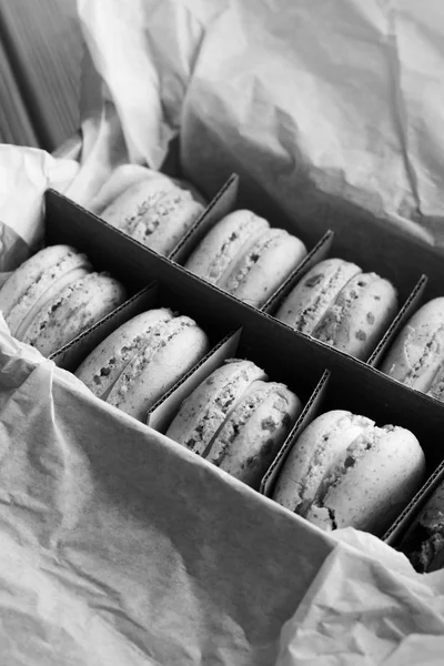 delicious macaroons in paper box, sweet dessert, black and white
