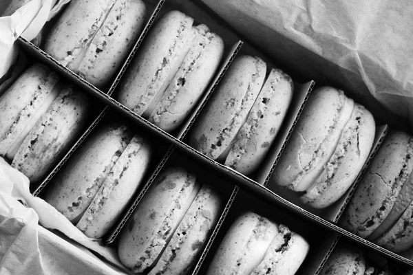delicious macaroons in paper box, sweet dessert, black and white