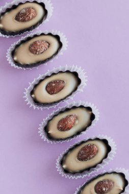 satır mor zemin üzerine badem ile lezzetli pralin tatlılar