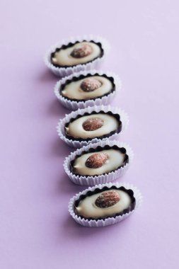 satır mor zemin üzerine badem ile lezzetli pralin tatlılar