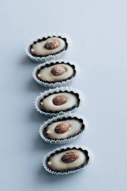 satır ile mavi arka plan üzerinde badem lezzetli pralin tatlılar