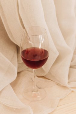 kadehinin ahşap masa ve beyaz Tekstil kırmızı şarap ile 