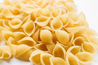 Beyaz arka plan üzerinde pişmemiş makarna yığını    