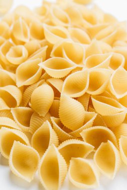 Beyaz arka plan üzerinde pişmemiş makarna yığını    
