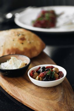 ev yapımı taze ekmek, humus ve zeytin ahşap tahta üzerinde 