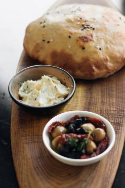 ev yapımı taze ekmek, humus ve zeytin ahşap tahta üzerinde 