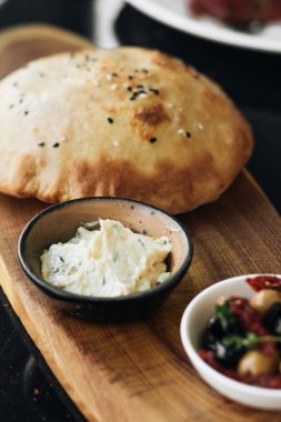 ev yapımı taze ekmek, humus ve zeytin ahşap tahta üzerinde 