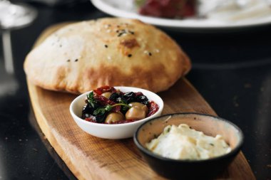 ev yapımı taze ekmek, humus ve zeytin ahşap tahta üzerinde 