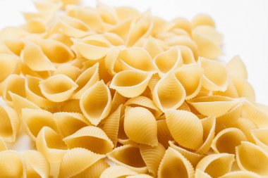 Beyaz arka plan üzerinde pişmemiş makarna yığını    