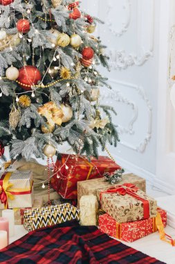 Noel ağacının altında sarılmış hediyeler