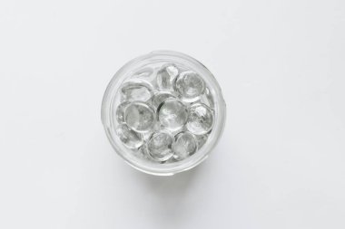 Beyaz arka planda kavanozda dağılmış kristaller, güzel mücevherler.