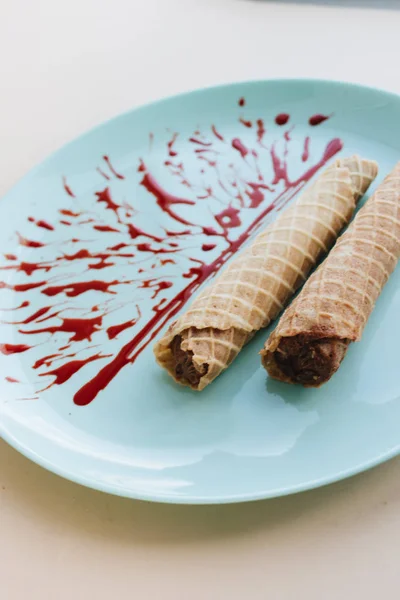 red caramel and waffle tubes with sweet filling  on plate