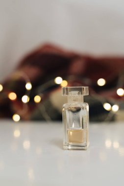 Arkaplanda altın bokeh ışıkları olan bir şişe parfüm. 