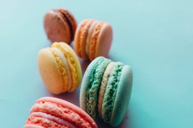 Mavi arka planda lezzetli renkli badem kurabiyelerinin kompozisyonu 