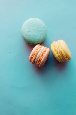 Mavi arka planda lezzetli renkli badem kurabiyelerinin kompozisyonu 