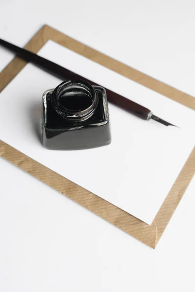一套老式的蘸笔 墨水和空白纸表与信封在白色的木桌 — 图库照片